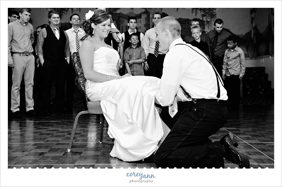 Kathleen and Derek's Canton Wedding groom removing garter during wedding reception