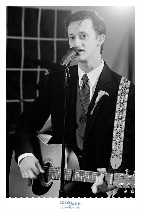 best man playing guitar during wedding reception
