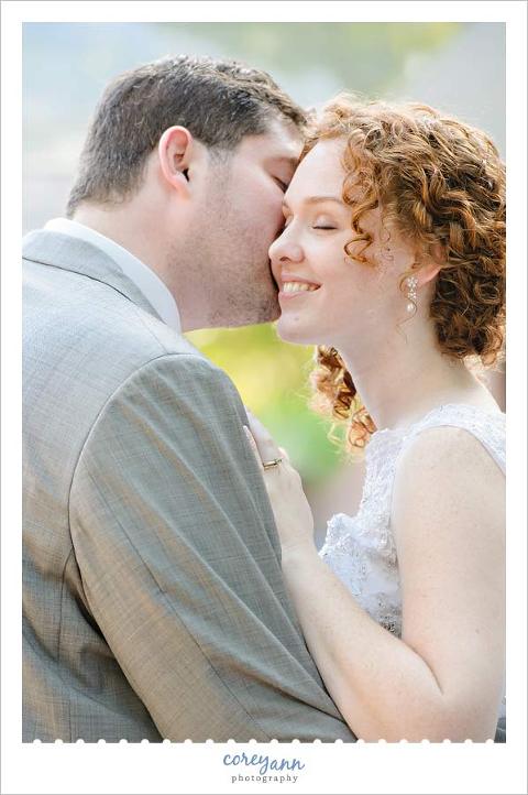 groom kissing bride on cheek during their first dance