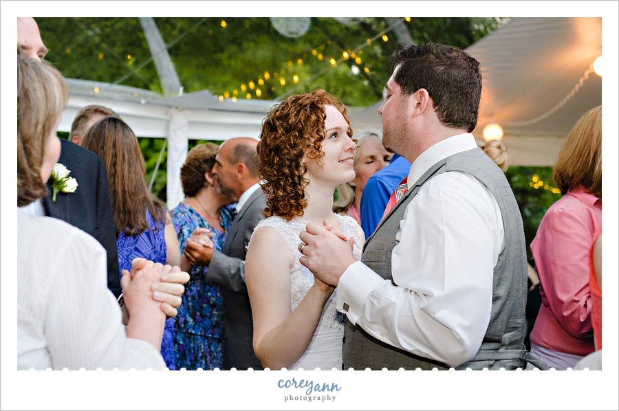 bride and groom dancing beneath clear wedding tent