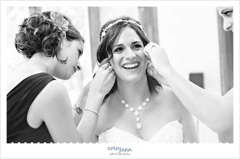 brides sisters helping her get ready for wedding
