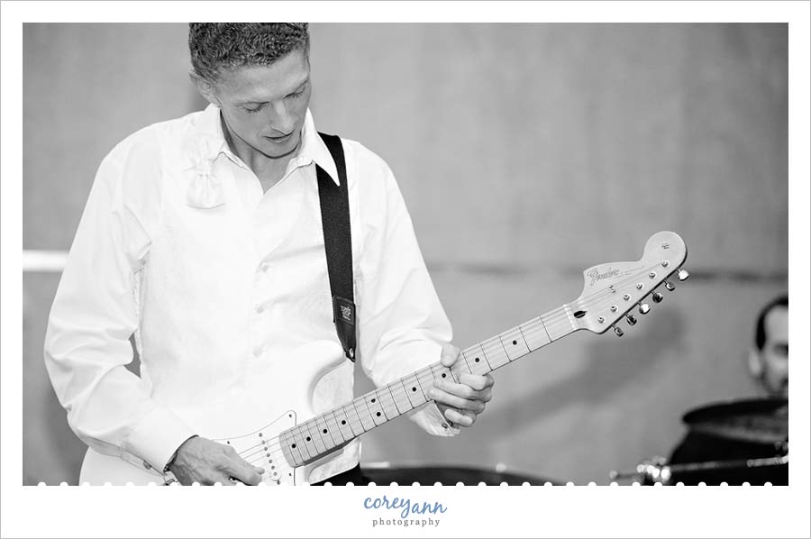 groom playing guitar with the band during wedding reception