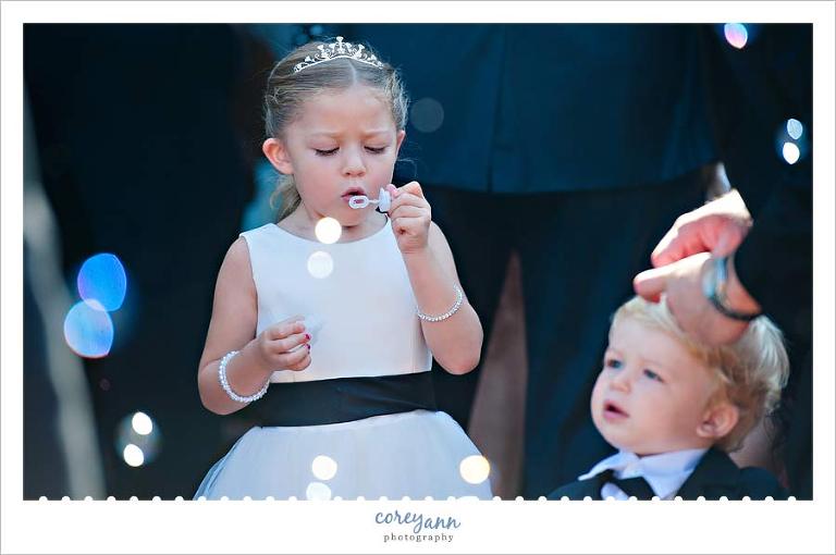 flower girl blowing bubbles for exit from wedding after ceremony