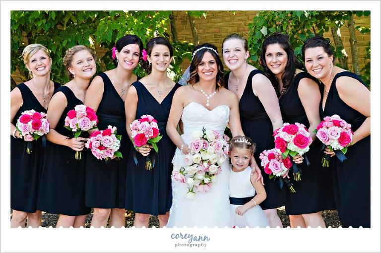bridesmaids in black dresses with pink bouquets 