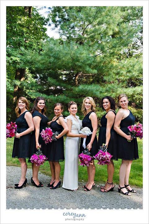 bridesmaids in black dresses with hot pink flowers