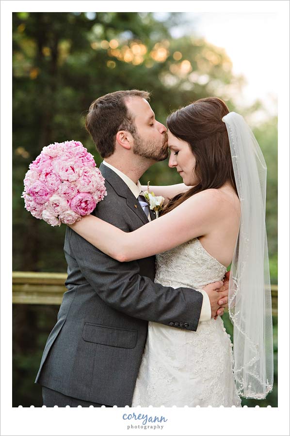 groom kissing bride on forehead
