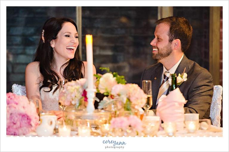 bride and groom at sweetheart table at wedding reception