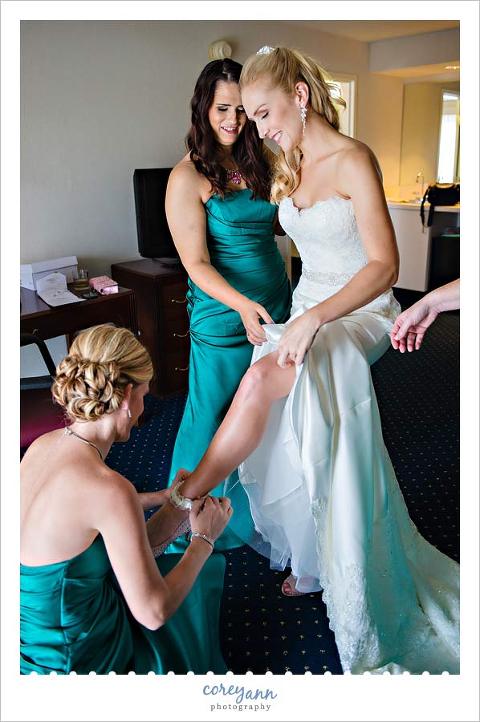 bridesmaids helping bride get ready before wedding