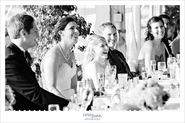 bride and groom laughing during toast during wedding reception