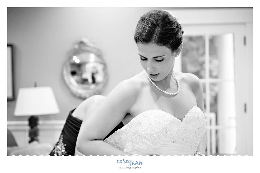 bride getting dressed for wedding