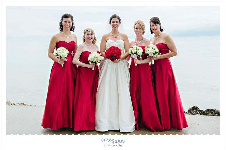bridesmaids with long red bridesmaids with white rose bouquets