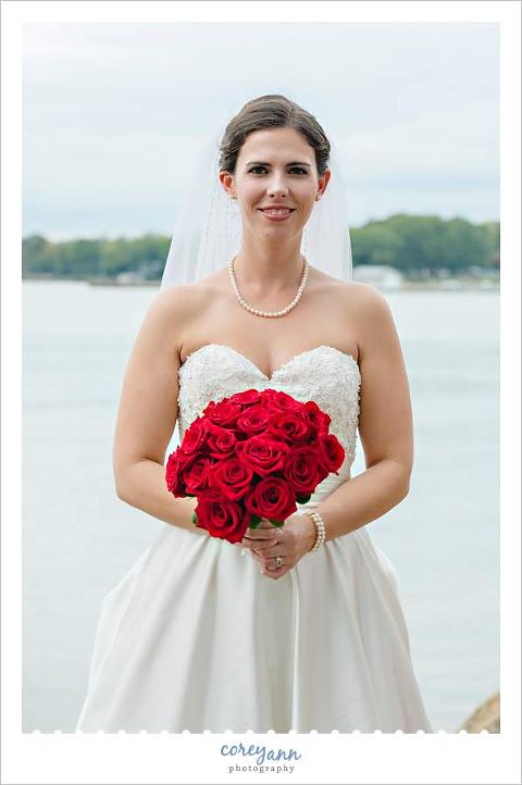 bridal portrait on lake erie with a red rose bouquet