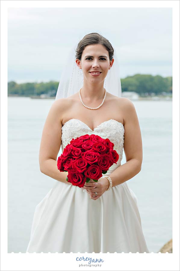 bridal portrait on lake erie with a red rose bouquet