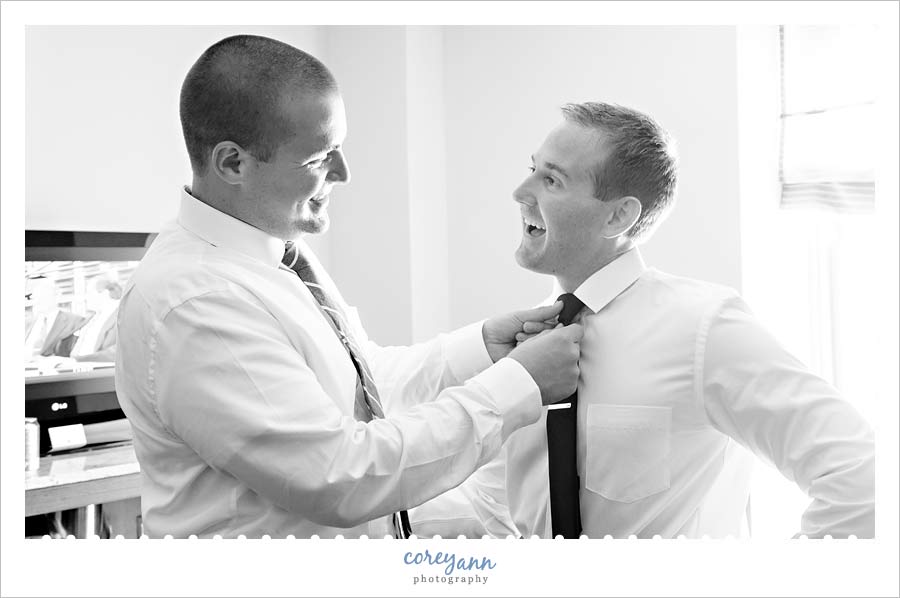 groomsman helping groom get ready