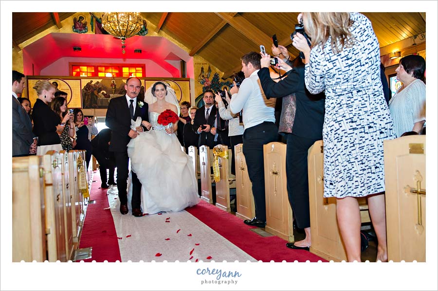 bride being escorted down the aisle to her husband