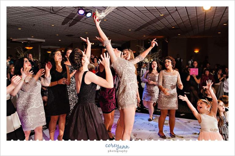 bridesmaid catching the bouquet during reception after wedding ceremony