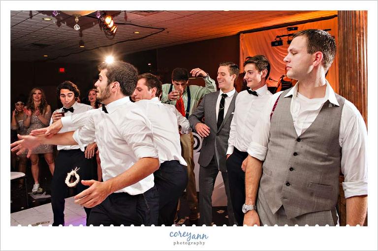 guys catching the garter at the wedding reception