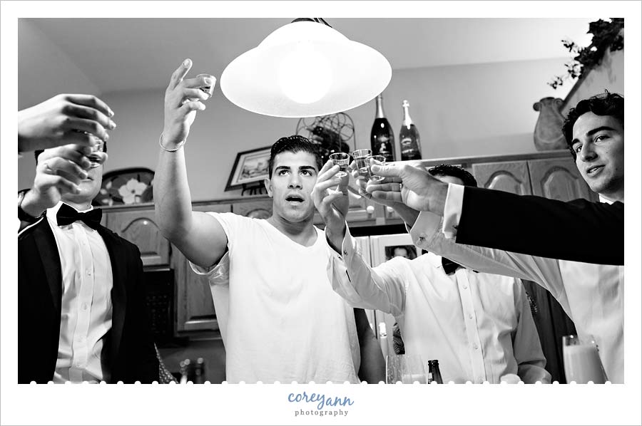 groom doing shots before getting ready for wedding