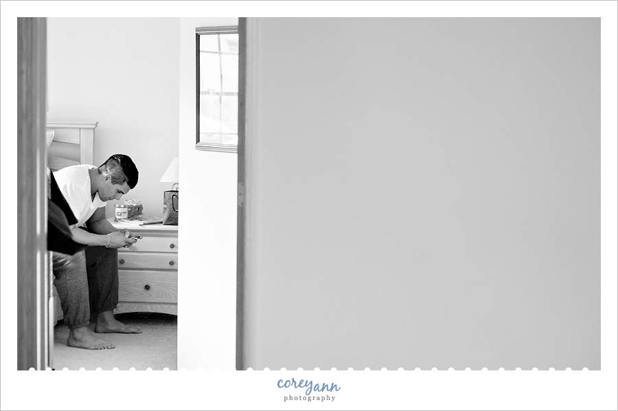 groom checking cell phone prior to getting ready