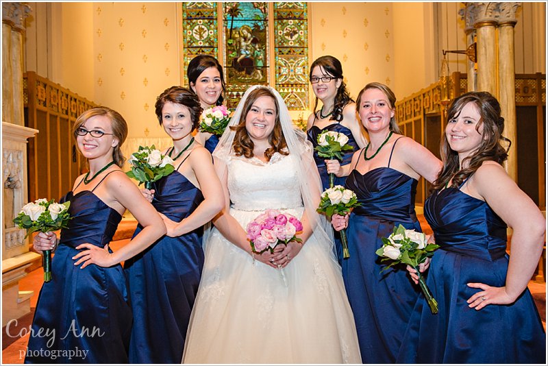 bridesmaids in long navy dresses with pink bouquets