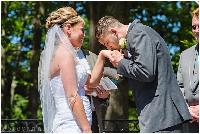groom kissing brides hand after placing ring on finger