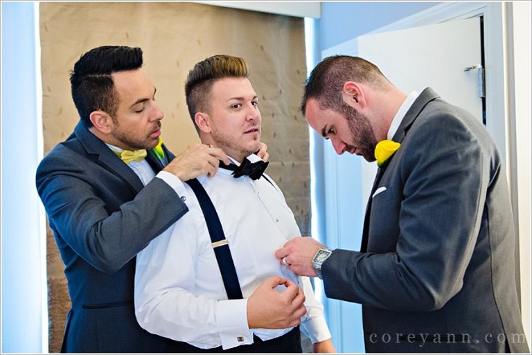 groomsman helping groom get ready before wedding ceremony