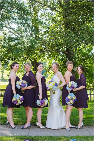 bridesmaids with short purple dresses and multi colored hydrangea bouquets