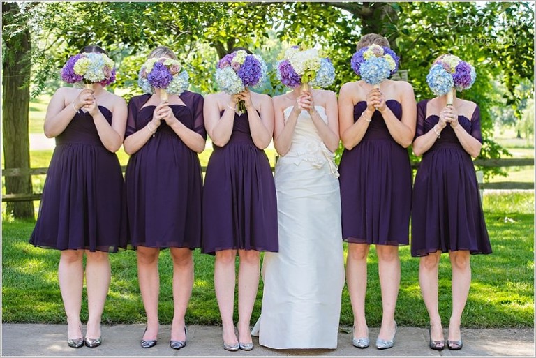 bridesmaids with bouquets over their heads
