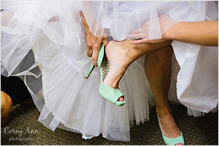bride putting on mint green heels