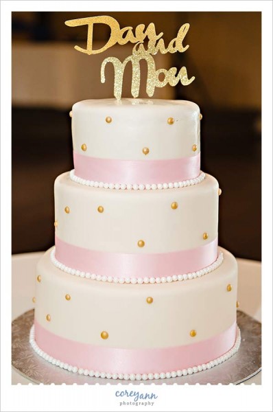 white cake with pink and gold polka dots