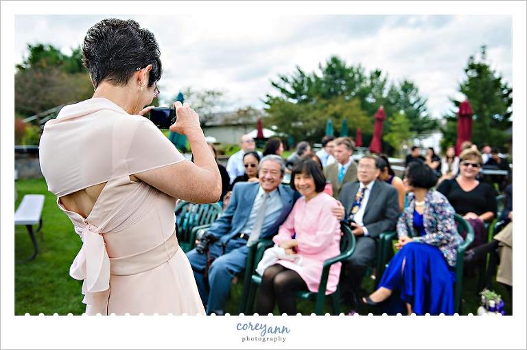 mom taking picture during wedding ceremony