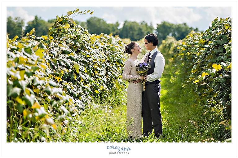bride and groom pose in vineyard at debonne vineyard in  madison ohio