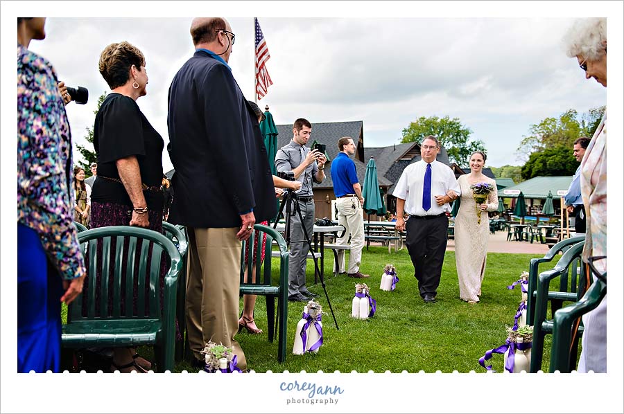 brides father escorting her down the aisle 