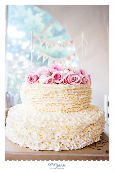 ruffled wedding cake with pink rose topper