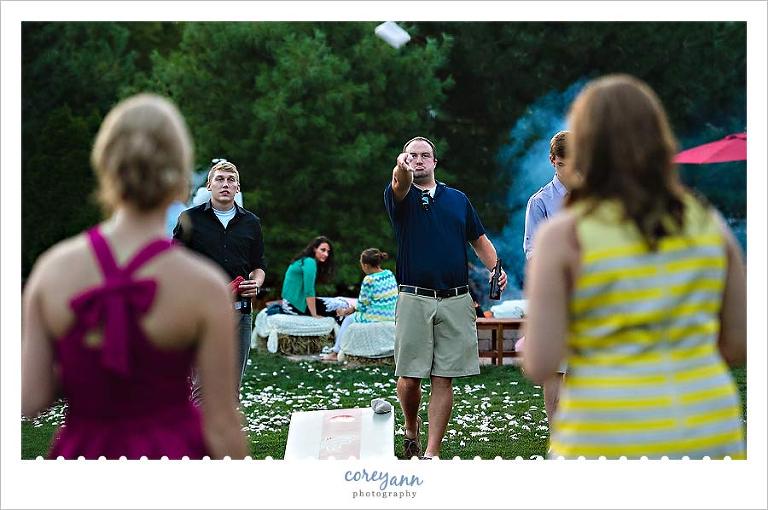 guest playing cornhole game during wedding reception