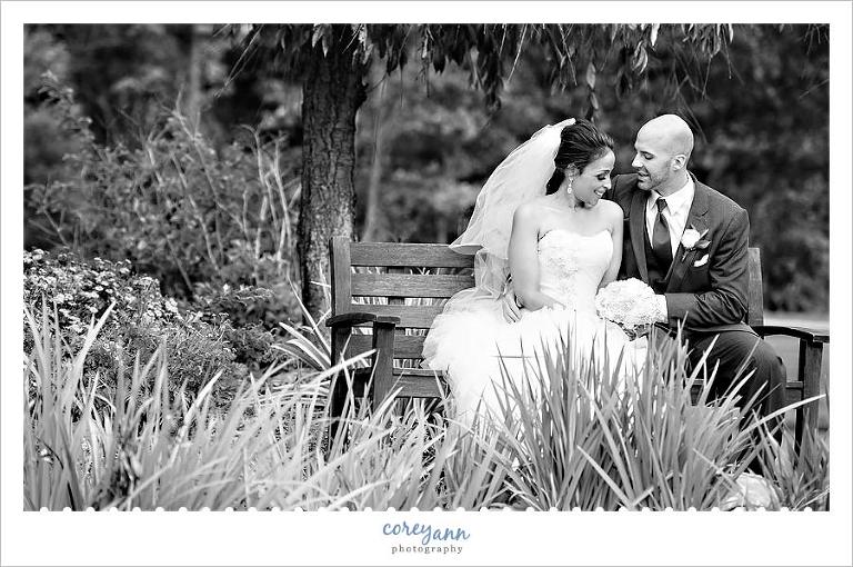 bride and groom posing on bench outside of cuyahoga valley church