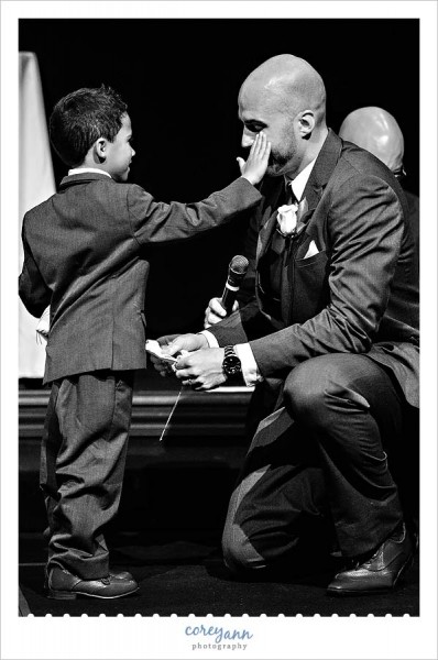 son wiping tear from stepfather's eye during wedding ceremony