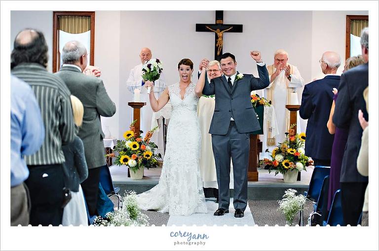 bride and groom cheering after wedding ceremony