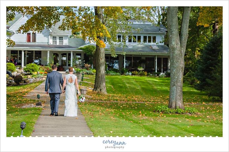 bride and groom walking towards the oaks restaurant in chippewa lake ohio