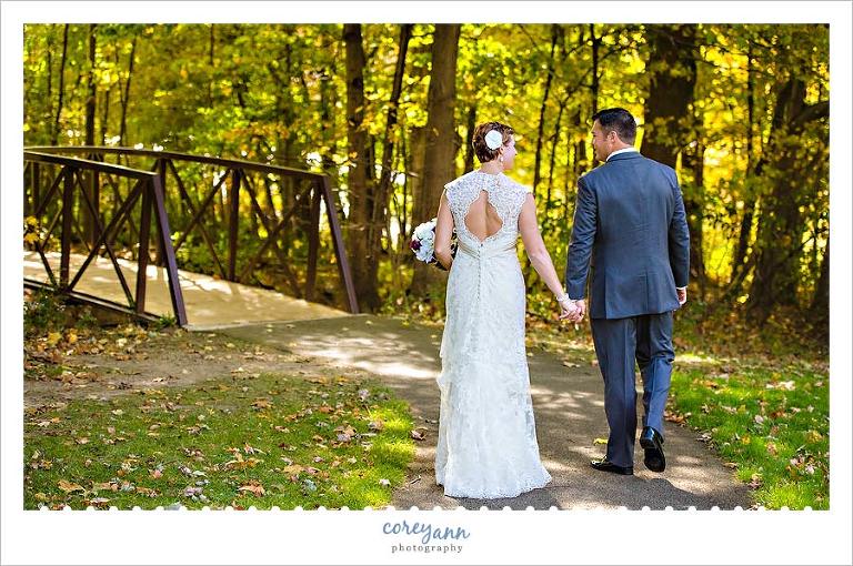 bride and groom walking towards bridge in ohio