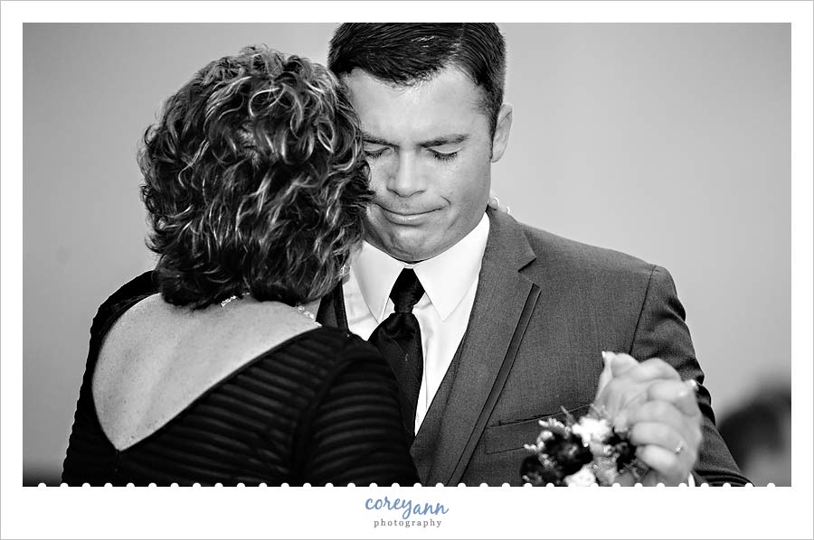 groom crying while dancing with his mom at wedding reception
