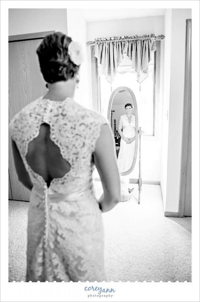bride looking in mirror  of her wedding dress