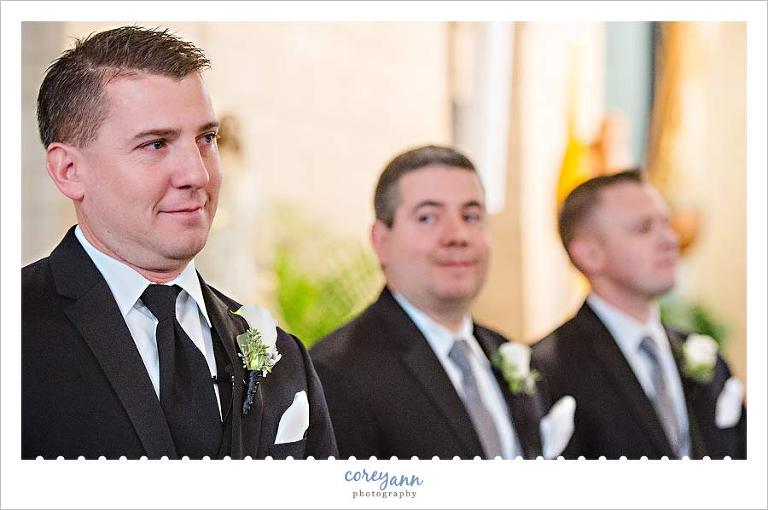 groom seeing bride as she walks up the aisle at wedding ceremony