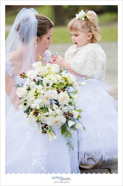 bride and flower girl playing with flower 