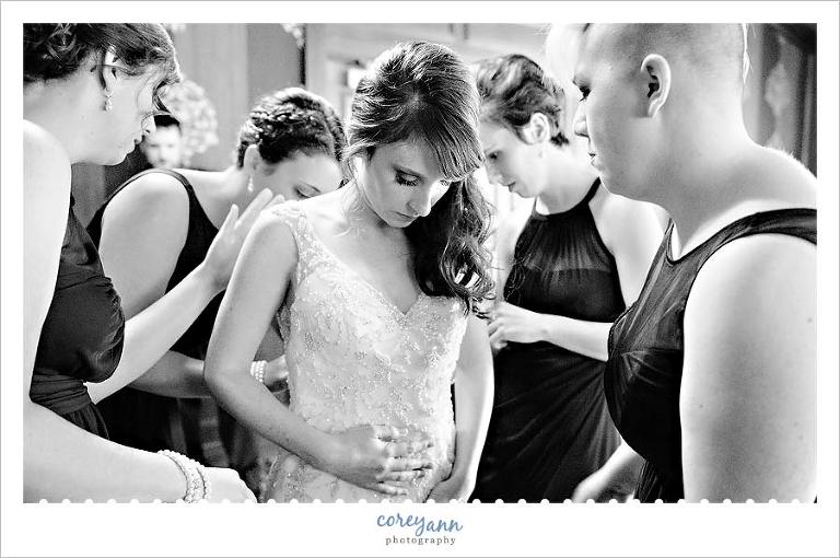 bride being helped getting ready by bridesmaid