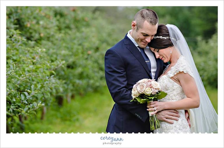bride and groom among apple trees in chesterland ohio