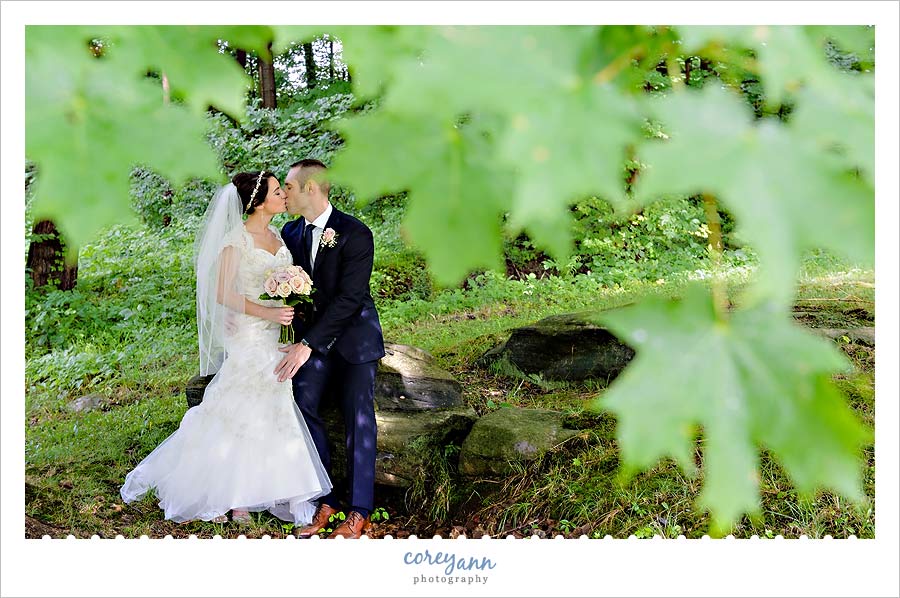 bride and groom kissing beneath a tree