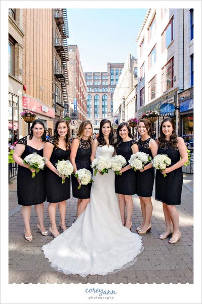 bridesmaids in various black lace dresses with white bouquets
