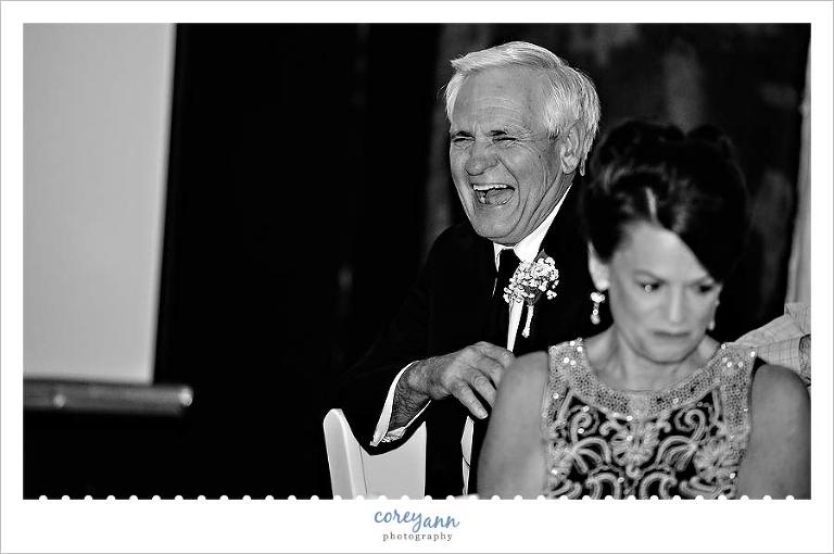 groom's father laughing during best man's toast at wedding reception in cleveland
