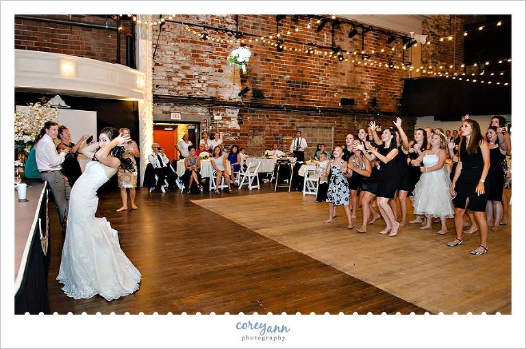 bride throwing bouquet at wedding reception at cleveland public theater